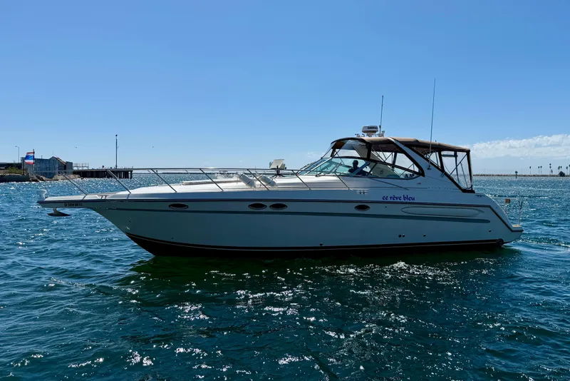 The Image of 1997 Maxum 4100 SCR yacht cruising on open water under clear blue sky. - 0