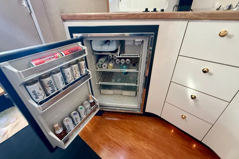 Slide: The Image of Mini fridge stocked with beverages inside a 1997 Maxum 4100 SCR yacht kitchen. - 18