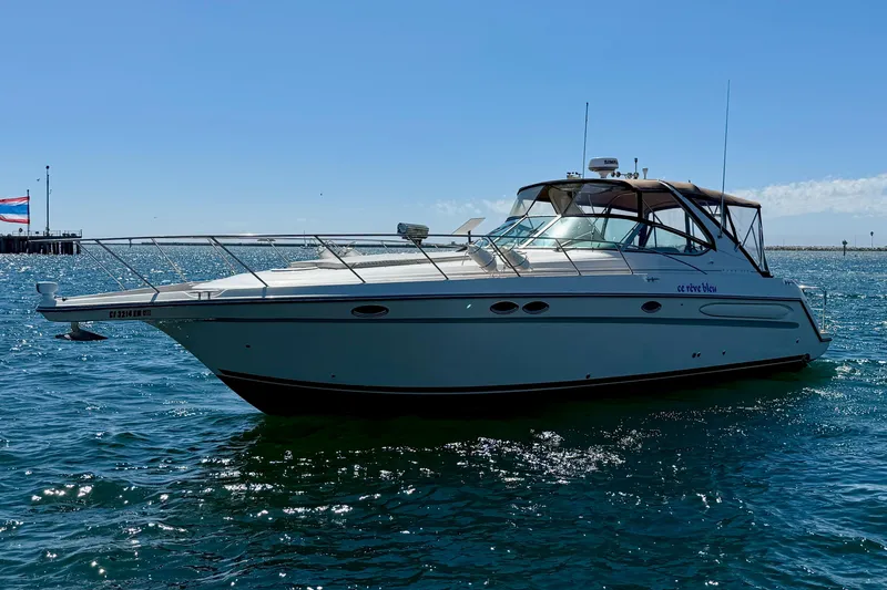 Slide: The Image of 1997 Maxum 4100 SCR yacht on open water under clear blue sky. - 2