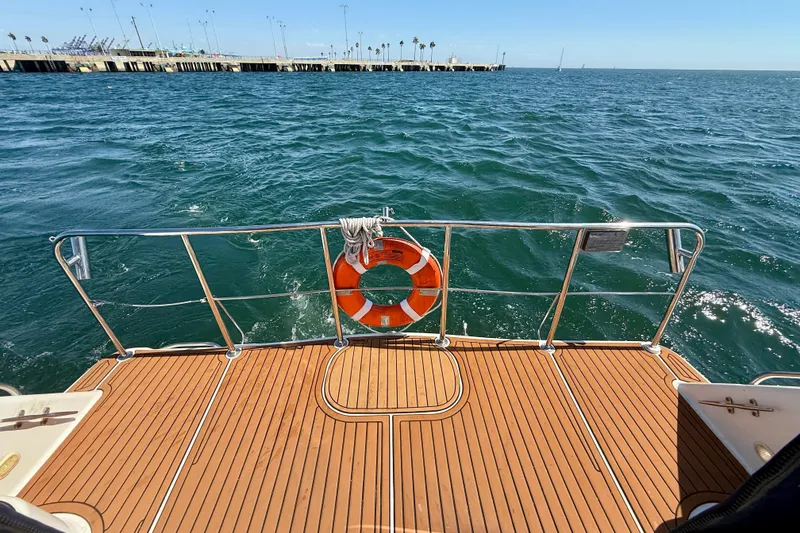 Slide: The Image of 1997 Maxum 4100 SCR boat deck with lifebuoy, overlooking calm ocean waters. - 22