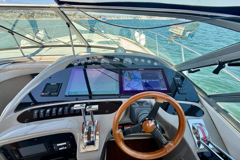 Slide: The Image of 1997 Maxum 4100 SCR yacht helm with modern navigation displays and wooden steering wheel. - 29