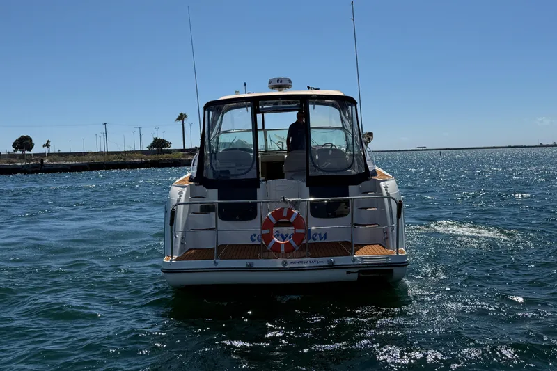 Slide: The Image of 1997 Maxum 4100 SCR boat on water, rear view, sunny day. - 3