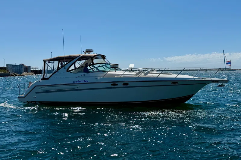 Slide: The Image of 1997 Maxum 4100 SCR yacht cruising on open water under clear blue sky. - 5