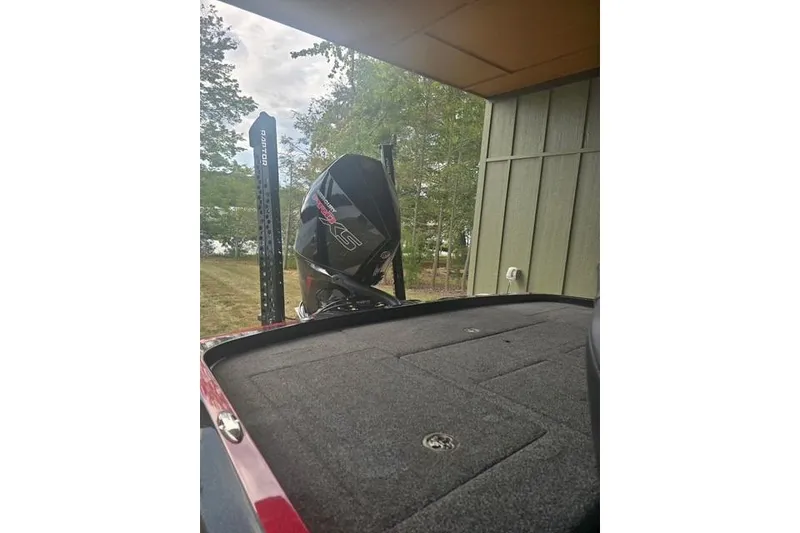 Slide: The Image of 2023 Nitro Z21 XL Pro boat with powerful engine, parked near a wooden structure. - 7