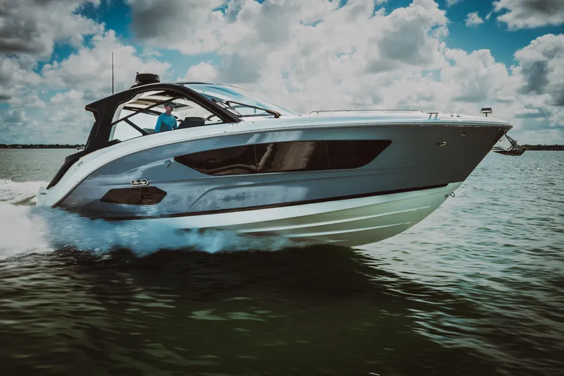 Slide: The Image of 2023 Sea Ray Sundancer 370 OB cruising on water under a partly cloudy sky. - 2