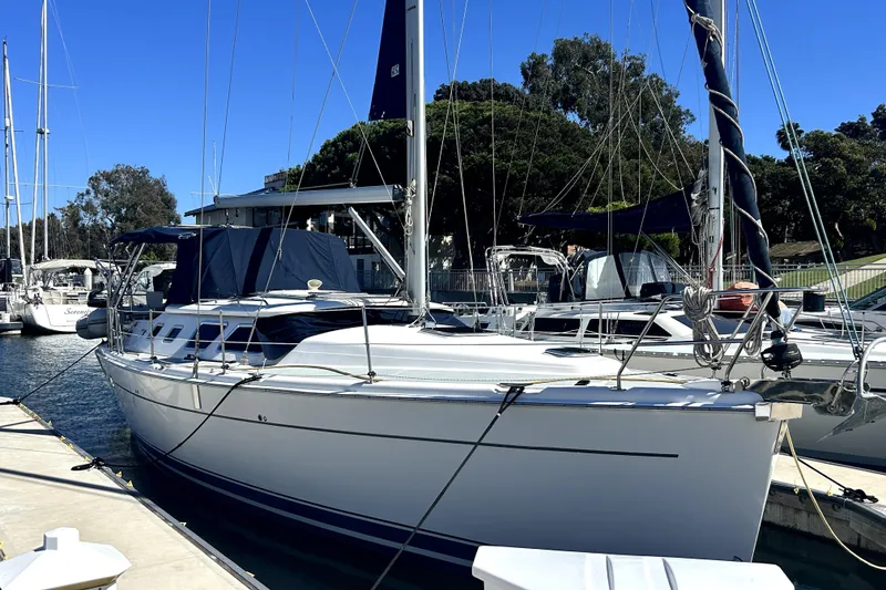 The Image of 2007 Hunter 41 Deck Salon sailboat with sails up on open water. - 0