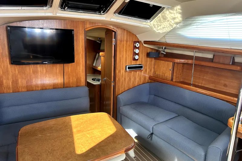 Slide: The Image of 2007 Hunter 41 Deck Salon navigation station with wood finish and communication equipment. - 20