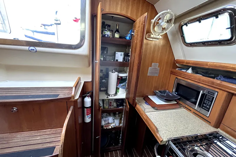 Slide: The Image of 2007 Hunter 41 Deck Salon sailboat docked in a marina under clear blue skies. - 5