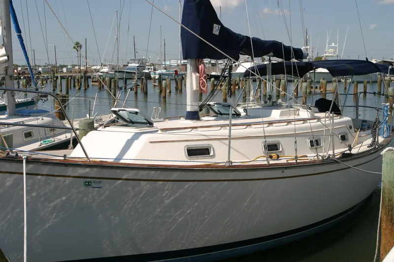 The Image of 1986 Island Packet 31 sailboat docked in a marina, featuring classic design and rigging. - 0