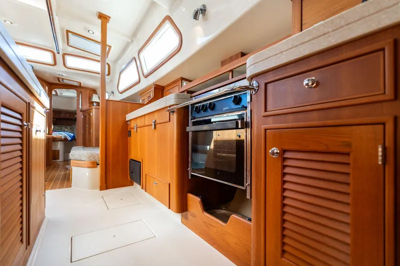Slide: The Image of Interior of 2008 Island Packet 465 yacht, featuring a well-equipped kitchen and cozy living space. - 10