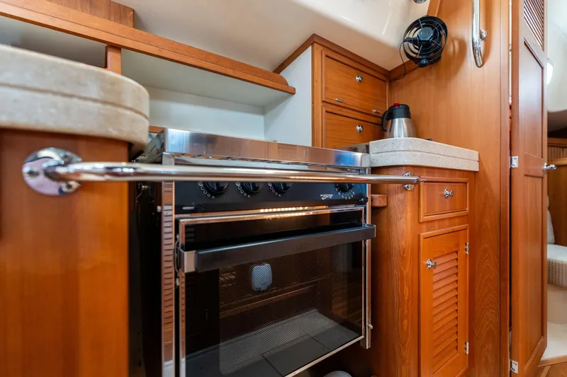 Slide: The Image of 2008 Island Packet 465 yacht kitchen with wooden cabinetry and stainless steel oven. - 11