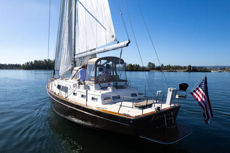 Slide: The Image of 2008 Island Packet 465 sailboat cruising on calm waters with American flag. - 3