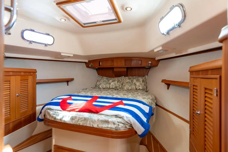 Slide: The Image of Cozy cabin interior of 2008 Island Packet 465 sailboat with bed and wooden cabinetry. - 35