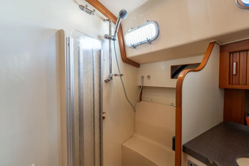 Slide: The Image of 2008 Island Packet 465 yacht bathroom with shower, wooden accents, and compact design. - 38