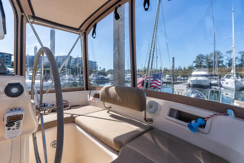 Slide: The Image of Interior view of 2008 Island Packet 465 sailboat cockpit with marina background. - 42