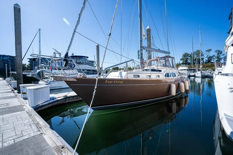 Slide: The Image of 2008 Island Packet 465 sailboat docked in a marina, reflecting on calm water. - 69