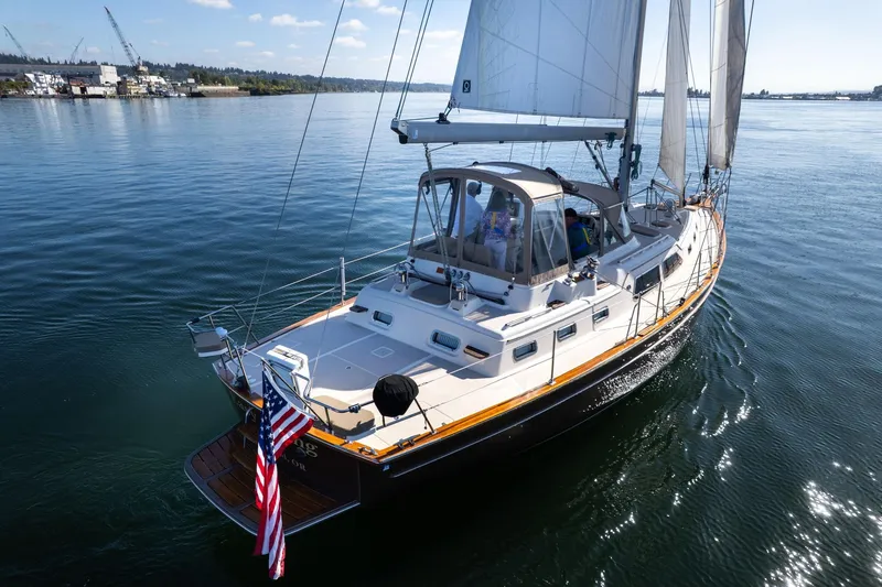 Slide: The Image of 2008 Island Packet 465 sailboat cruising on calm waters with American flag. - 70
