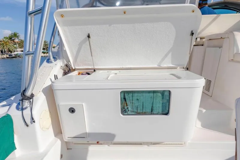 Slide: The Image of 2004 Pursuit 3800 Express boat with open storage compartment, dockside view. - 11