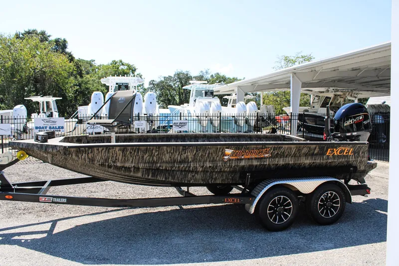 Slide: The Image of 2026 Excel Tomahawk 183 boat on trailer, parked outdoors near a brick building. - 0