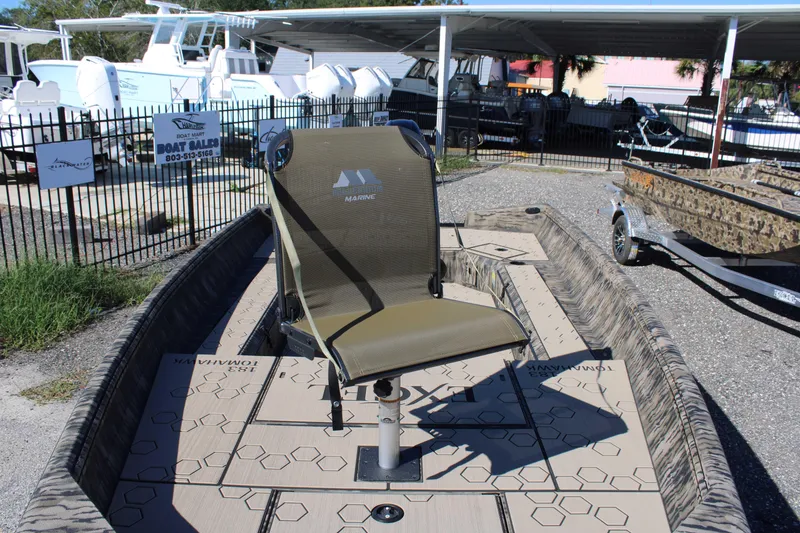 Slide: The Image of 2026 Excel Tomahawk 183 boat with swivel chair, displayed at a boat dealership. - 14