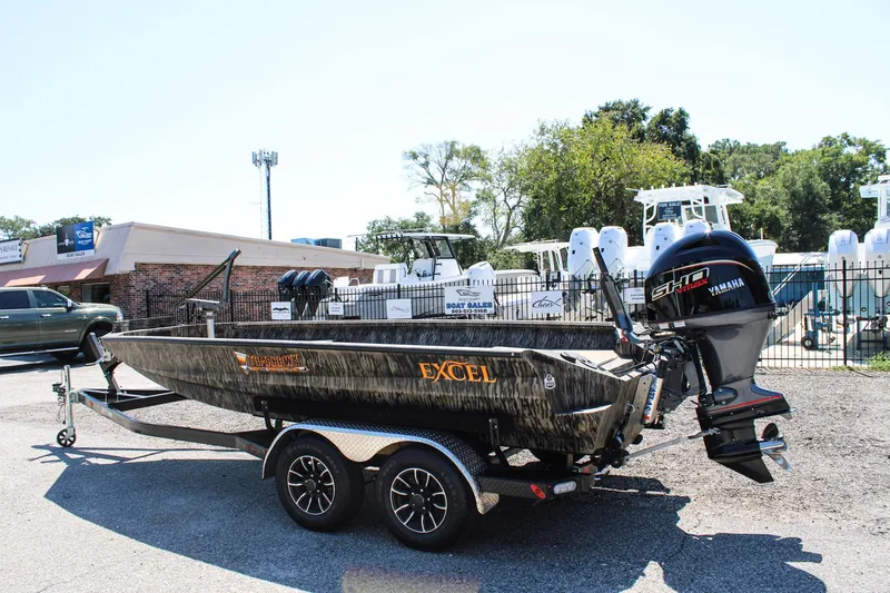 Slide: The Image of 2026 Excel Tomahawk 183 boat on trailer, parked outdoors with trees in background. - 4