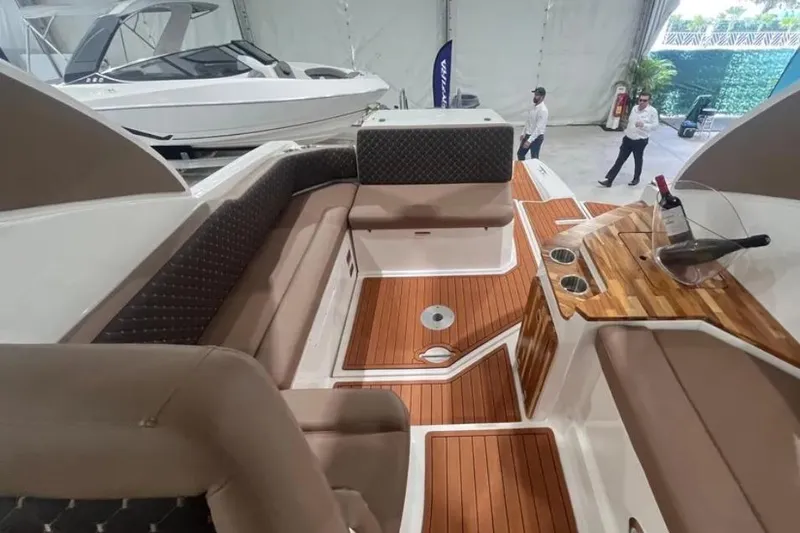 Slide: The Image of 2025 Ventura Daycruiser interior with elegant seating and wooden accents in a showroom. - 3