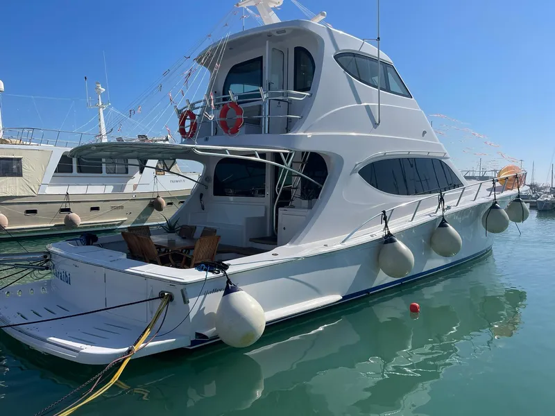 Slide: The Image of 2013 Hatteras GT63 yacht docked in marina, featuring sleek design and spacious deck. - 1
