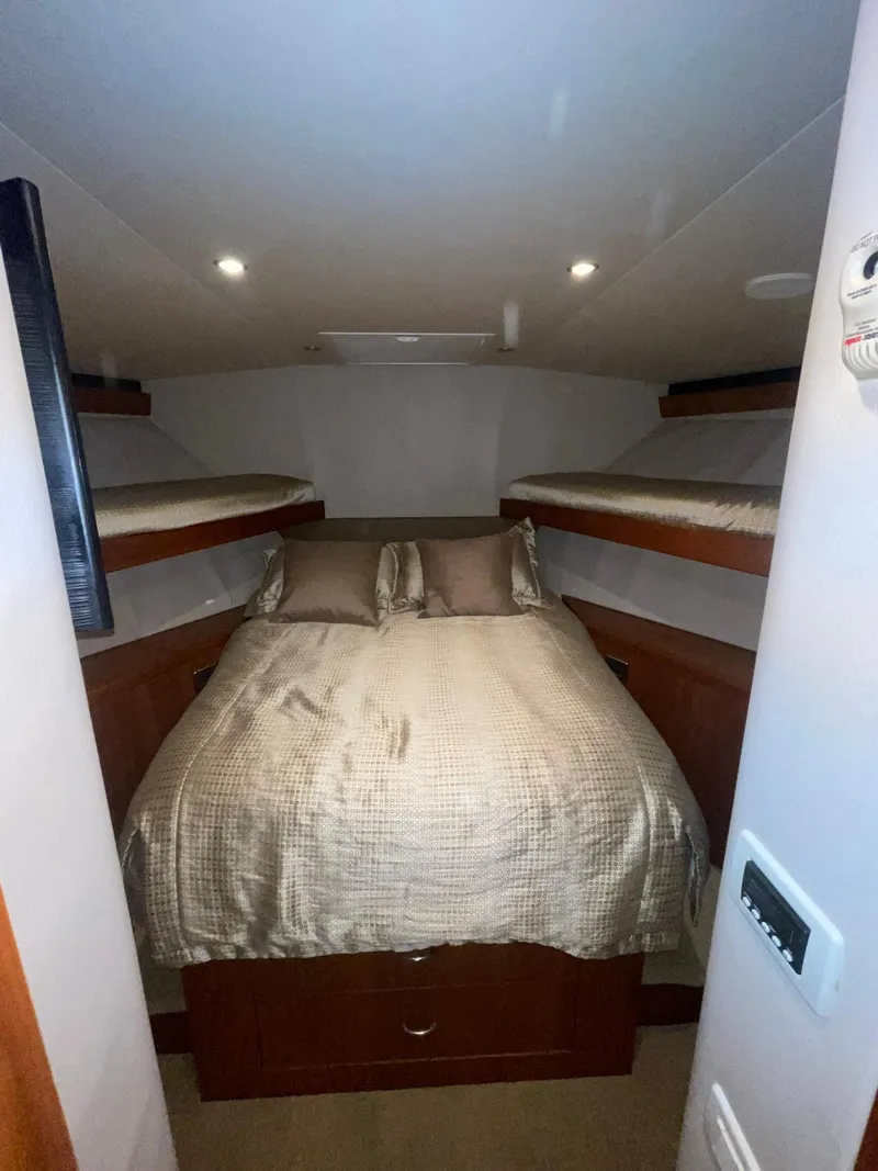 Slide: The Image of 2013 Hatteras GT63 yacht cabin with double bed and bunk beds. - 10