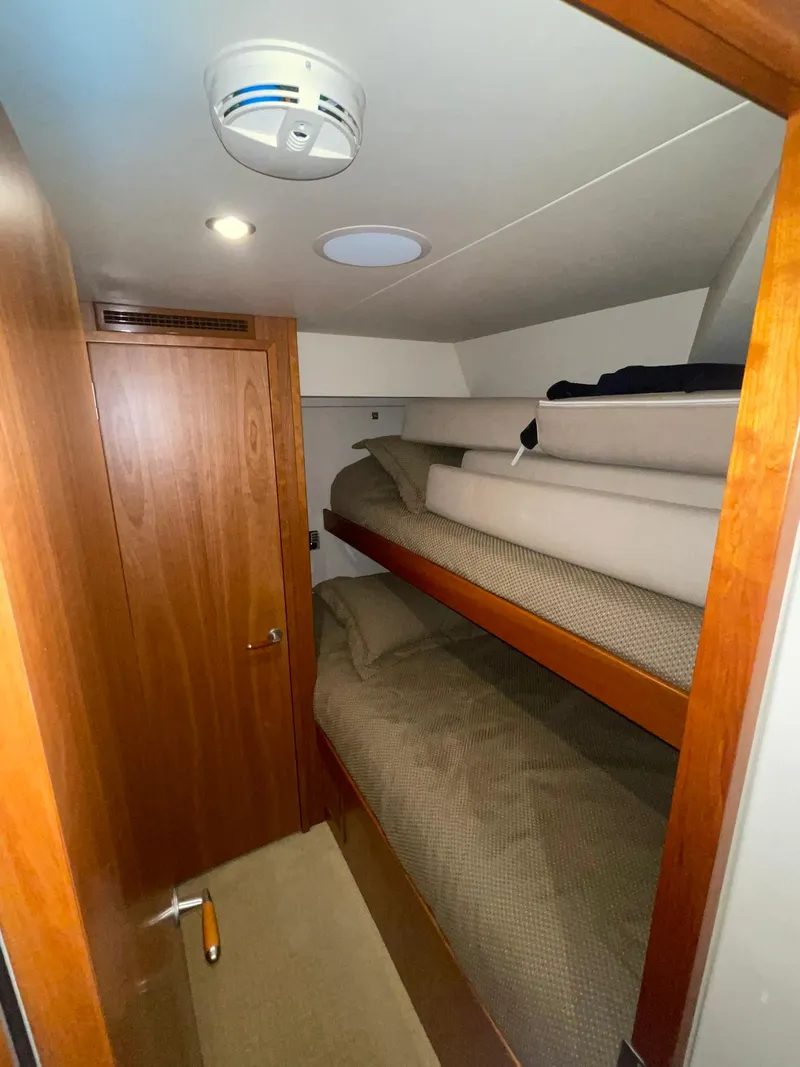 Slide: The Image of Bunk beds in 2013 Hatteras GT63 yacht cabin with wooden door and smoke detector. - 18