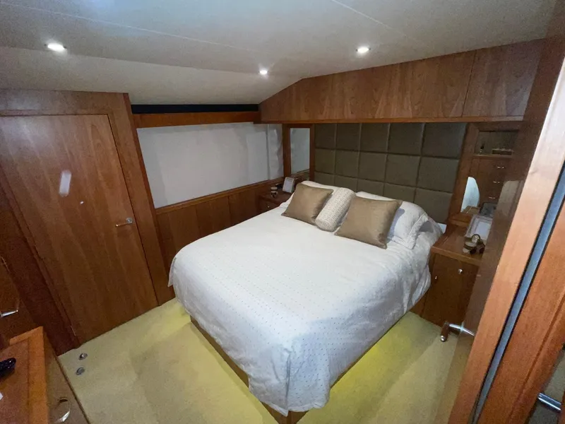 Slide: The Image of Luxurious bedroom interior of 2013 Hatteras GT63 yacht with wooden accents and cozy bedding. - 19