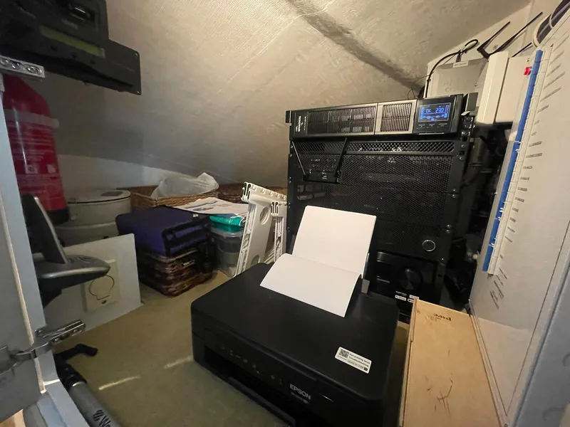 Slide: The Image of Small storage room with office equipment, including a printer and server, aboard a 2013 Hatteras GT63. - 25