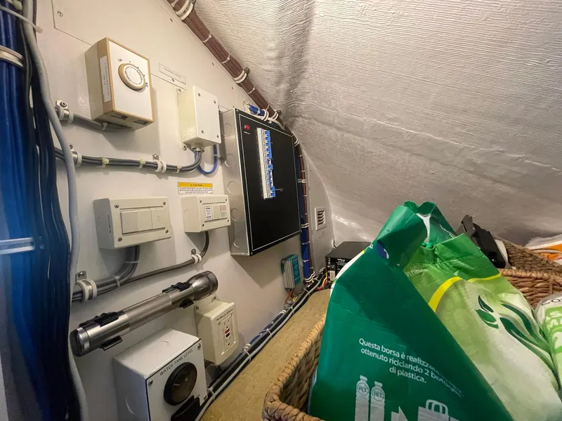 Slide: The Image of Electrical control room inside a 2013 Hatteras GT63 yacht, featuring various panels and equipment. - 29