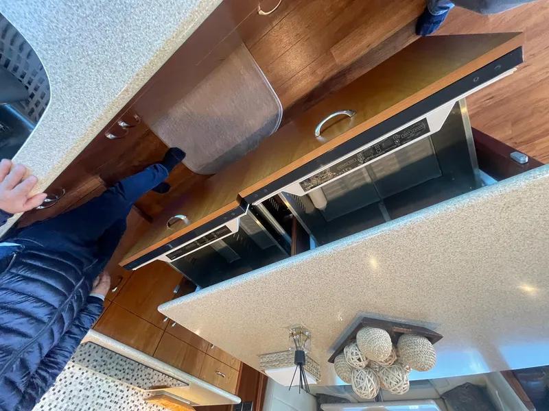 Slide: The Image of Interior of 2013 Hatteras GT63 yacht kitchen with modern appliances and wooden cabinetry. - 33