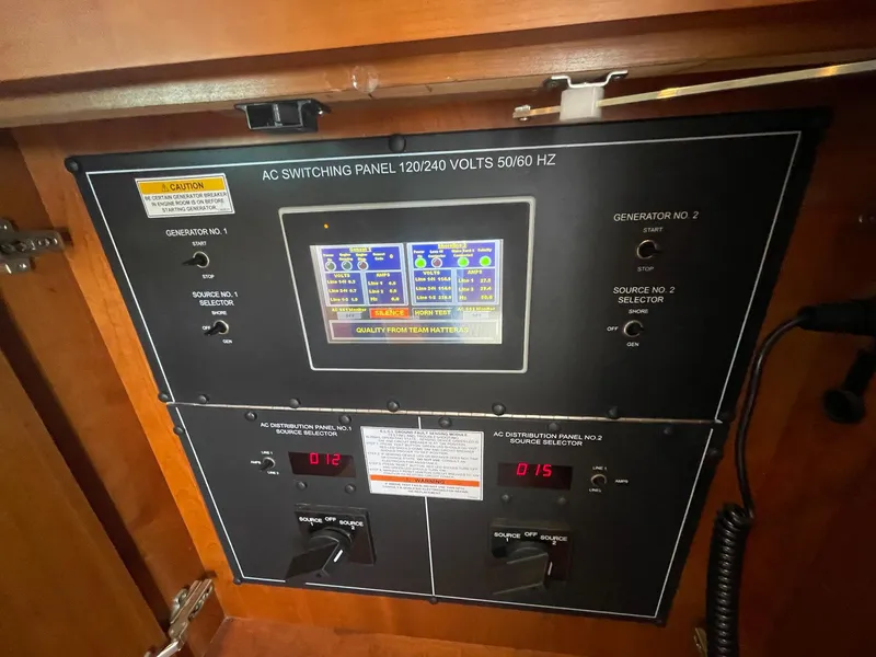 Slide: The Image of AC switching panel on 2013 Hatteras GT63 yacht, displaying voltage and generator controls. - 45