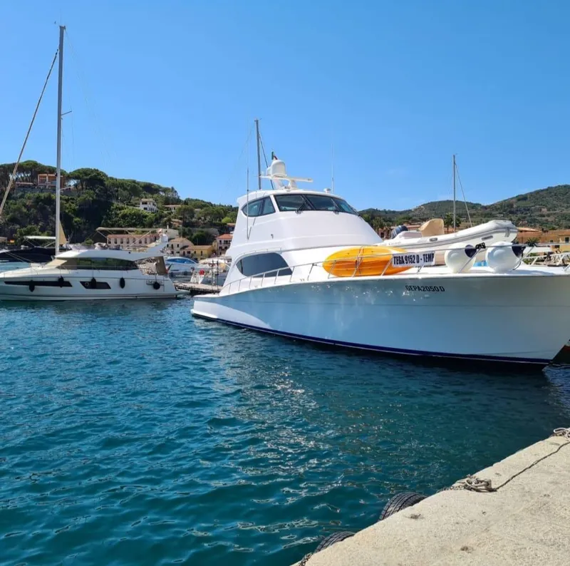 Slide: The Image of 2013 Hatteras GT63 yacht docked in a scenic marina with clear blue water. - 5
