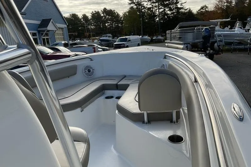 Slide: The Image of 2023 Key West 203 FS boat interior with seating and cup holders, parked outdoors. - 11
