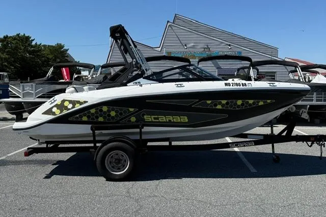 The Image of 2020 Scarab 195 ID boat on trailer, parked in marina lot. - 1