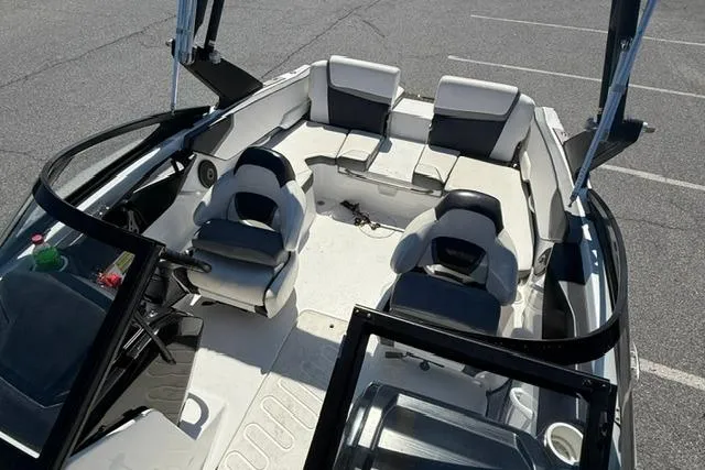 Slide: The Image of 2020 Scarab 195 ID boat interior with seating and steering wheel in a parking lot. - 10