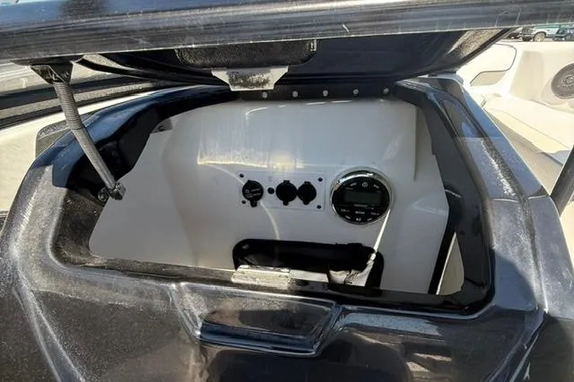 Slide: The Image of 2020 Scarab 195 ID boat storage compartment with open lid, showcasing interior controls. - 11