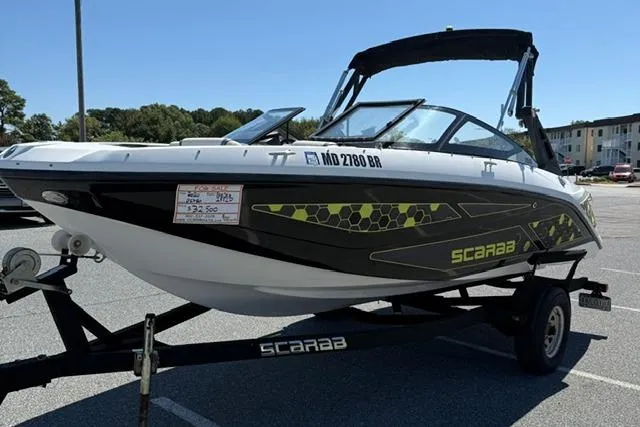 Slide: The Image of 2020 Scarab 195 ID boat on trailer, black and white design, parked outdoors. - 4