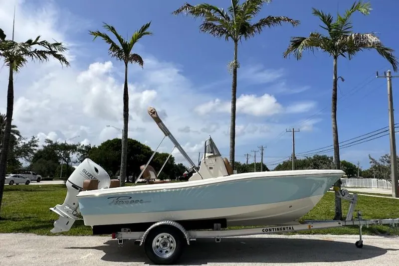 The Image of 2025 Pioneer 180 Islander boat on trailer, parked under palm trees, clear blue sky. - 0