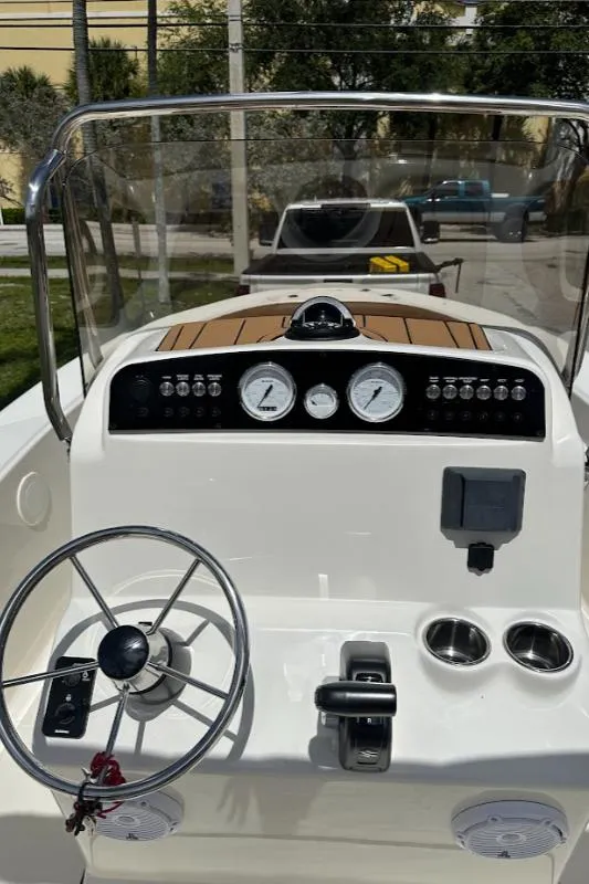 Slide: The Image of 2025 Pioneer 180 Islander boat dashboard with steering wheel and gauges. - 7