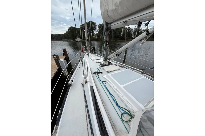 Slide: The Image of 1988 Sparkman & Stephens 36 sailboat docked by a serene lake. - 11