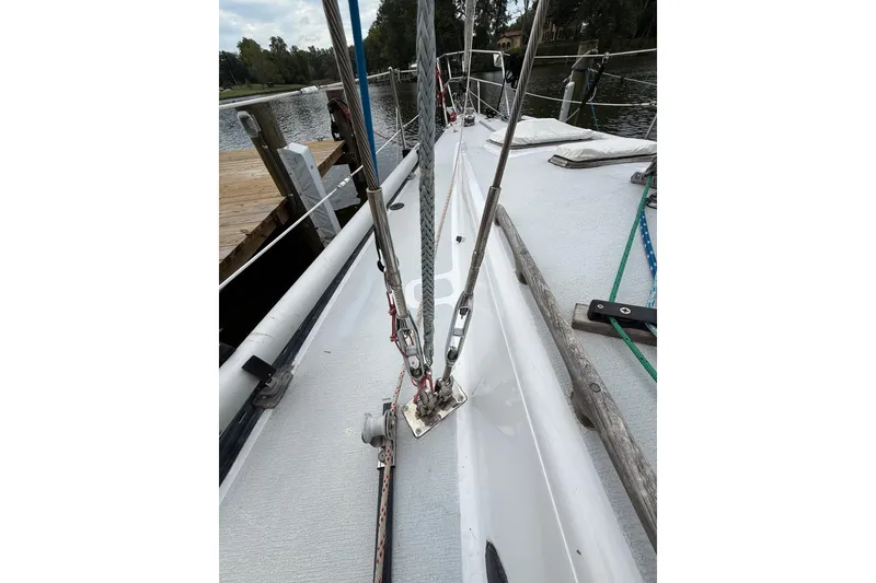 Slide: The Image of 1988 Sparkman & Stephens 36 sailboat deck with rigging, docked by a serene waterfront. - 12