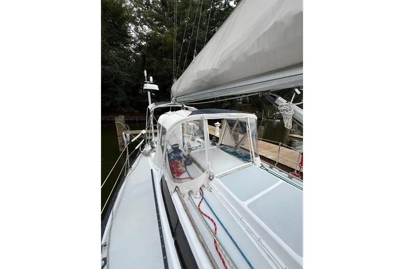 Slide: The Image of 1988 Sparkman & Stephens 36 sailboat docked, featuring a sleek deck and canopy. - 15