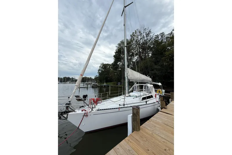 Slide: The Image of Sailboat docked, Sparkman & Stephens 36, 1988 model, on a calm waterfront. - 2