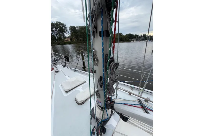Slide: The Image of 1988 Sparkman & Stephens 36 sailboat deck with rigging, docked by a calm lake. - 46