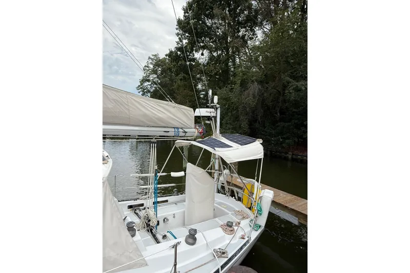 Slide: The Image of 1988 Sparkman & Stephens 36 sailboat docked, featuring solar panels and lush surroundings. - 6