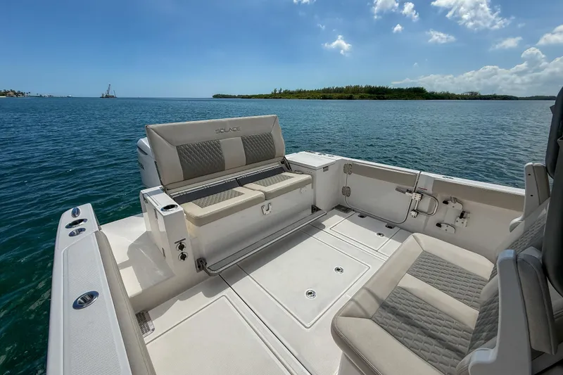 Slide: The Image of 2026 Solace 30 CS boat interior with seating, overlooking calm blue waters. - 7