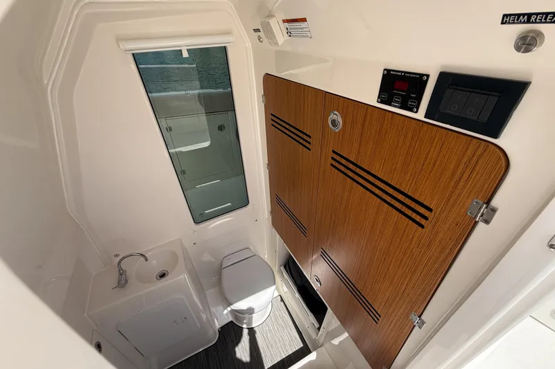 Slide: The Image of 2026 Solace 30 CS boat interior with separate wet head, sink, and storage cabinet. - 8